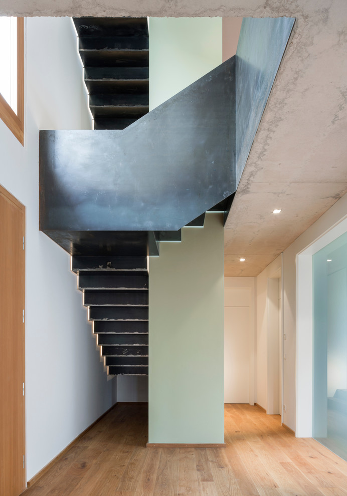 Mittelgroße Industrial Metalltreppe in L-Form mit Metall-Setzstufen und Stahlgeländer in Nürnberg