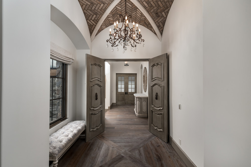 Inspiration for an expansive mediterranean hallway in Phoenix with multi-coloured walls, dark hardwood floors, multi-coloured floor, vaulted and brick walls.