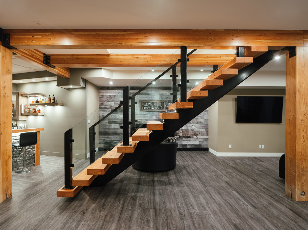 Photo of a mid-sized contemporary walk-out basement in Vancouver with a game room, beige walls, linoleum floors, grey floor and exposed beam.