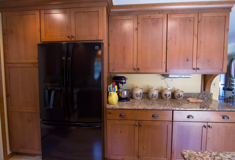 Mid-sized mountain style u-shaped light wood floor eat-in kitchen photo with an undermount sink, shaker cabinets, medium tone wood cabinets, quartz countertops, black appliances and a peninsula