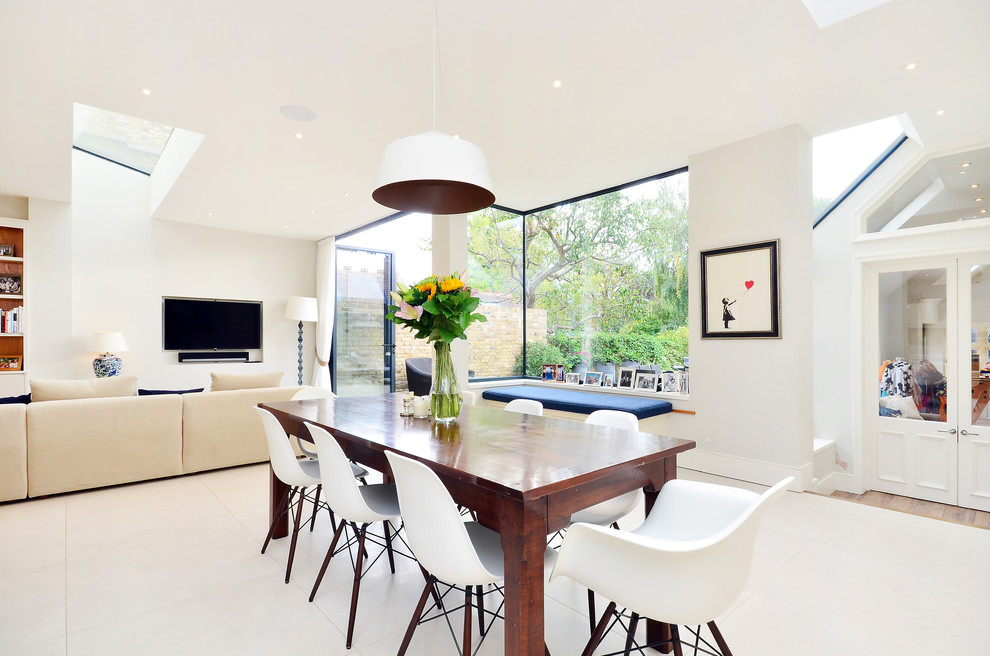 Contemporary open plan dining in London with white walls, ceramic floors and no fireplace.