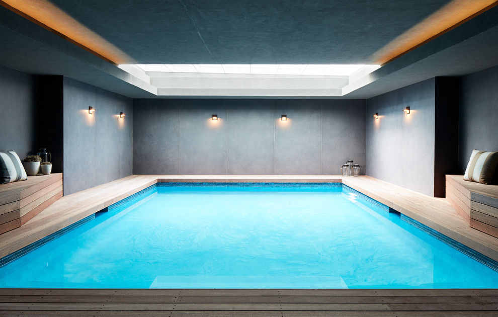Photo of a mid-sized modern indoor rectangular pool in Other with decking.