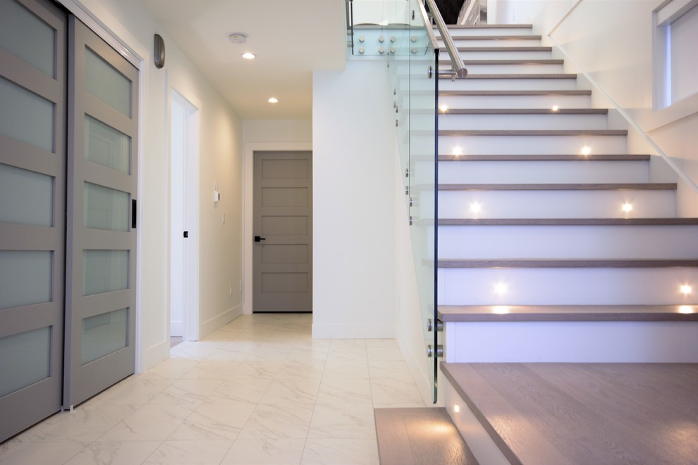 Mid-sized contemporary foyer in Vancouver with white walls, ceramic floors, a single front door, a light wood front door and white floor.