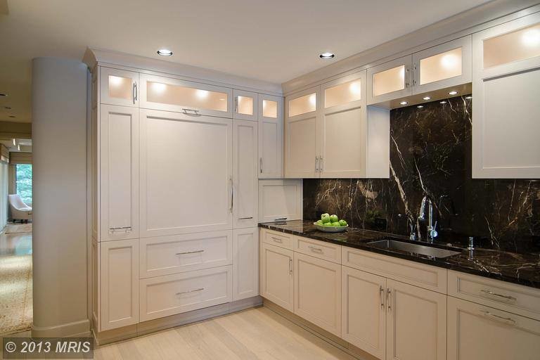 Mid-sized transitional l-shaped light wood floor and brown floor eat-in kitchen photo in Baltimore with an undermount sink, shaker cabinets, white cabinets, granite countertops, gray backsplash, porcelain backsplash, stainless steel appliances and an island