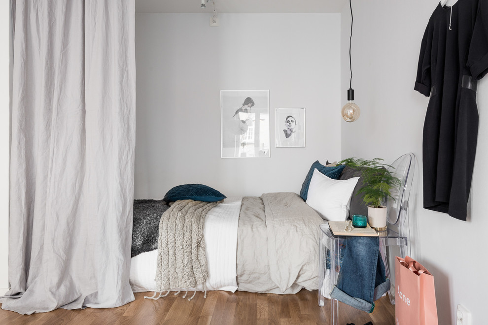 Design ideas for a small scandinavian master bedroom in Gothenburg with white walls, medium hardwood floors and no fireplace.