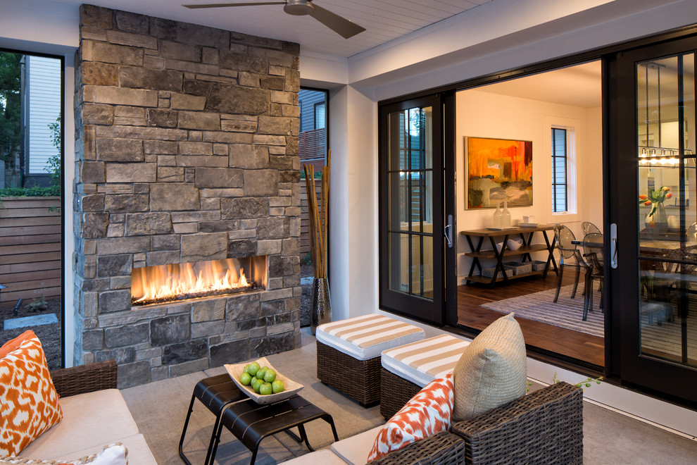 Example of a transitional backyard patio design in Minneapolis with a roof extension and a fireplace