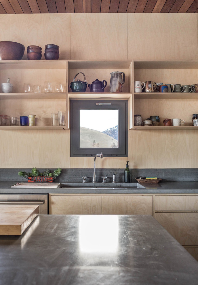 Inspiration for a mid-sized scandinavian l-shaped open plan kitchen in Other with an undermount sink, flat-panel cabinets, light wood cabinets, concrete benchtops, black splashback, timber splashback, stainless steel appliances, concrete floors, with island and grey floor.