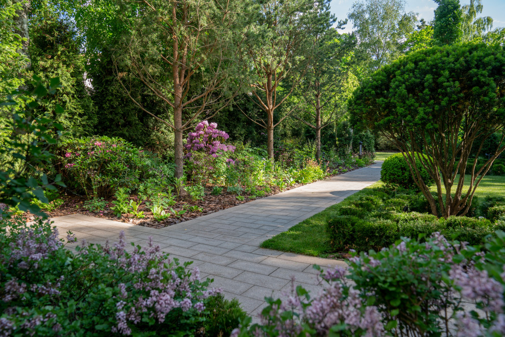 Exemple d'un jardin à la française arrière chic de taille moyenne et l'été avec un massif de fleurs, une exposition partiellement ombragée, des pavés en pierre naturelle et une clôture en bois.
