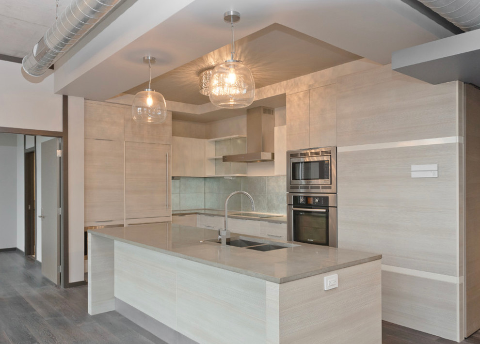 Inspiration for a mid-sized modern l-shaped eat-in kitchen in Houston with a double-bowl sink, flat-panel cabinets, beige cabinets, limestone benchtops, white splashback, glass sheet splashback, stainless steel appliances, medium hardwood floors and with island.