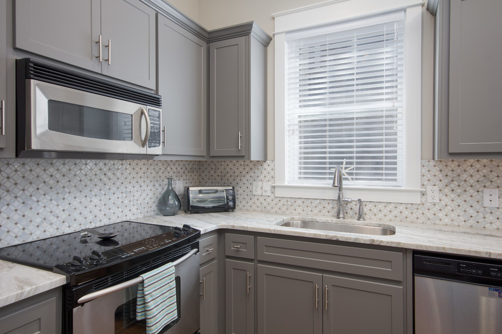 Inspiration for a mid-sized transitional l-shaped eat-in kitchen remodel in Miami with an undermount sink, shaker cabinets, gray cabinets, stainless steel appliances and an island