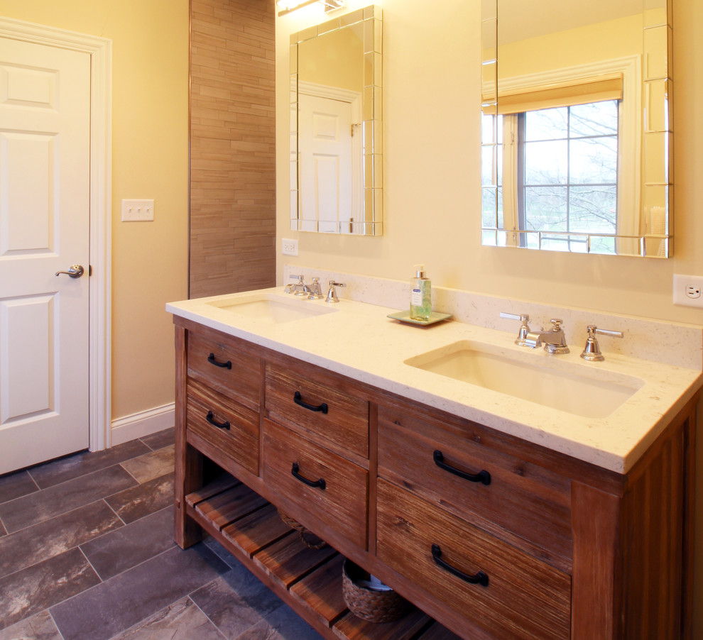 Mountain style gray tile and porcelain tile pebble tile floor doorless shower photo in Chicago with furniture-like cabinets, distressed cabinets, a one-piece toilet, beige walls, an undermount sink and quartz countertops