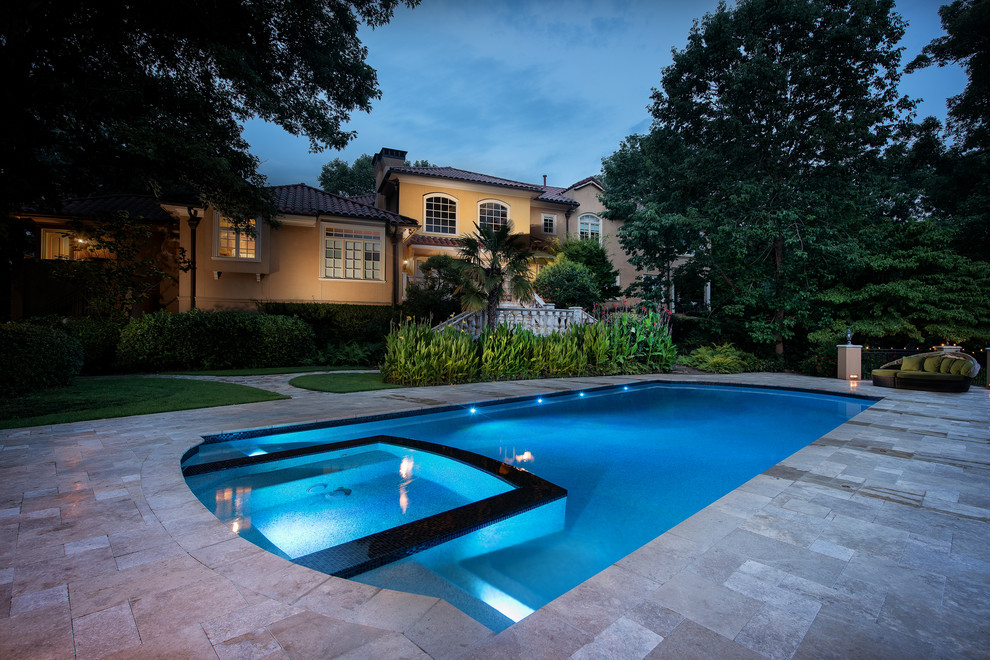 This is an example of a large mediterranean backyard custom-shaped pool in Atlanta with a hot tub.