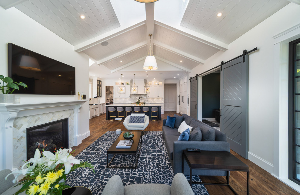 Mid-sized transitional open concept family room in Vancouver with white walls, dark hardwood floors, a standard fireplace, a wall-mounted tv, brown floor, exposed beam, timber, vaulted and a tile fireplace surround.