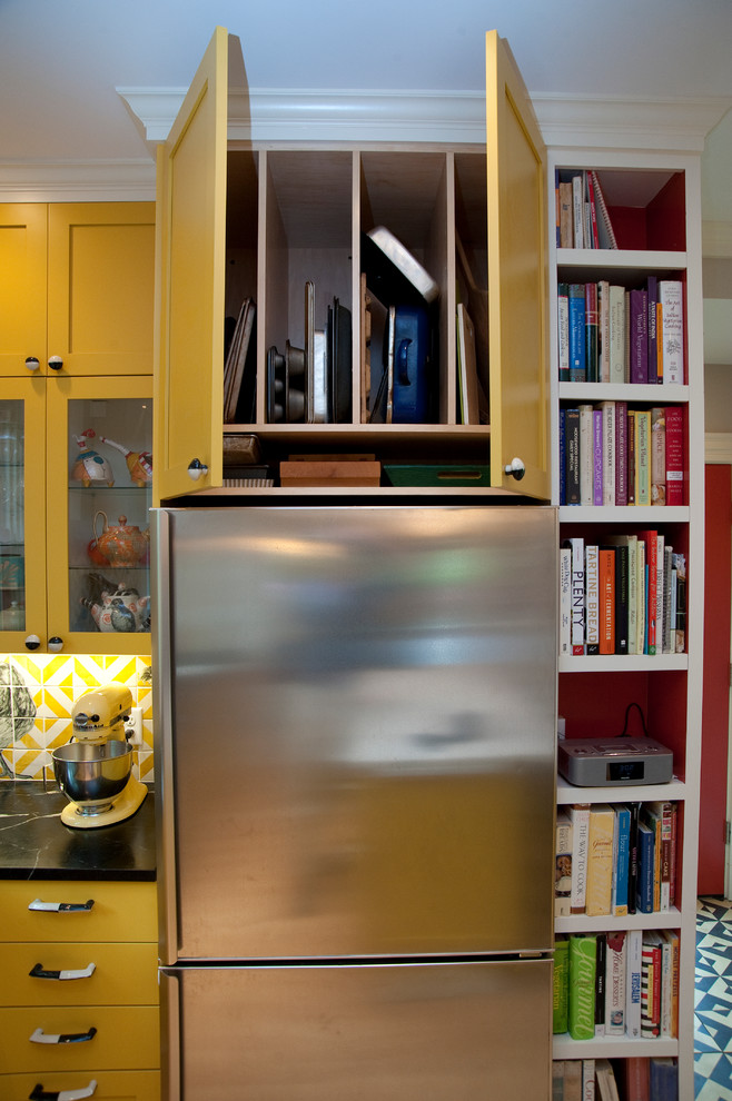 Photo of a mid-sized eclectic l-shaped separate kitchen in Boston with an undermount sink, shaker cabinets, yellow cabinets, soapstone benchtops and stainless steel appliances.