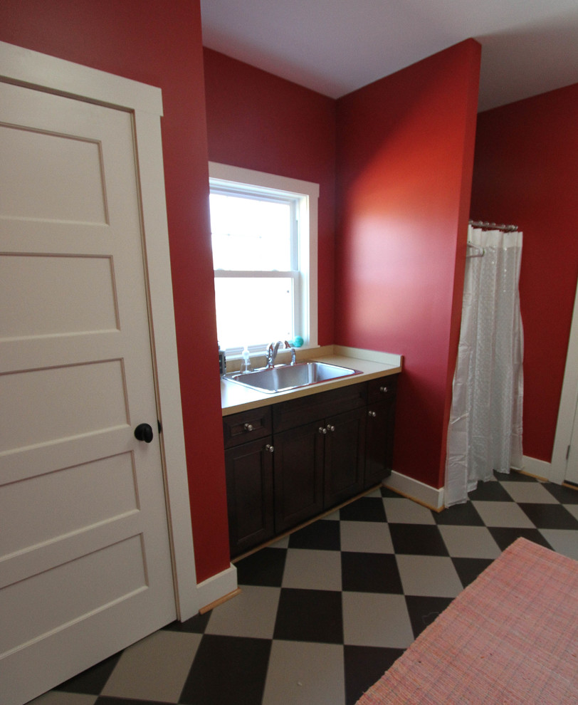 Photo of a large traditional galley utility room in DC Metro with a drop-in sink, raised-panel cabinets, dark wood cabinets, laminate benchtops, red walls and ceramic floors.