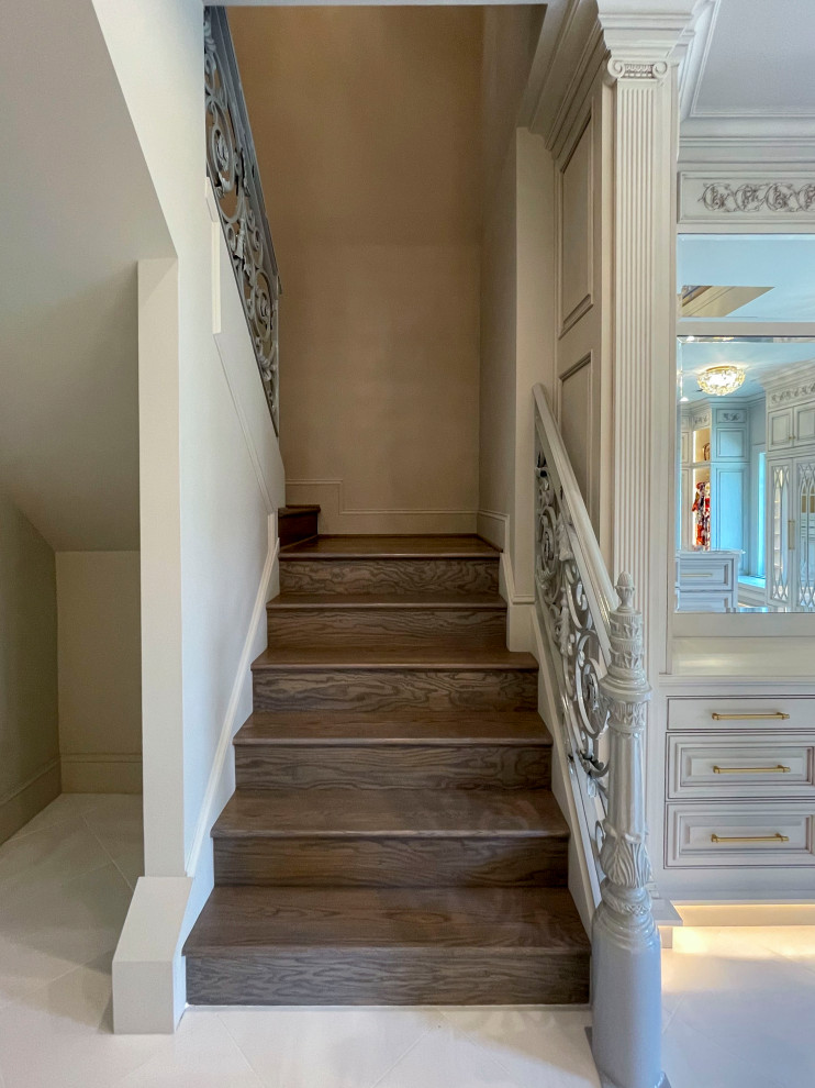 Photo of an expansive transitional wood floating staircase in DC Metro with wood risers, metal railing and panelled walls.