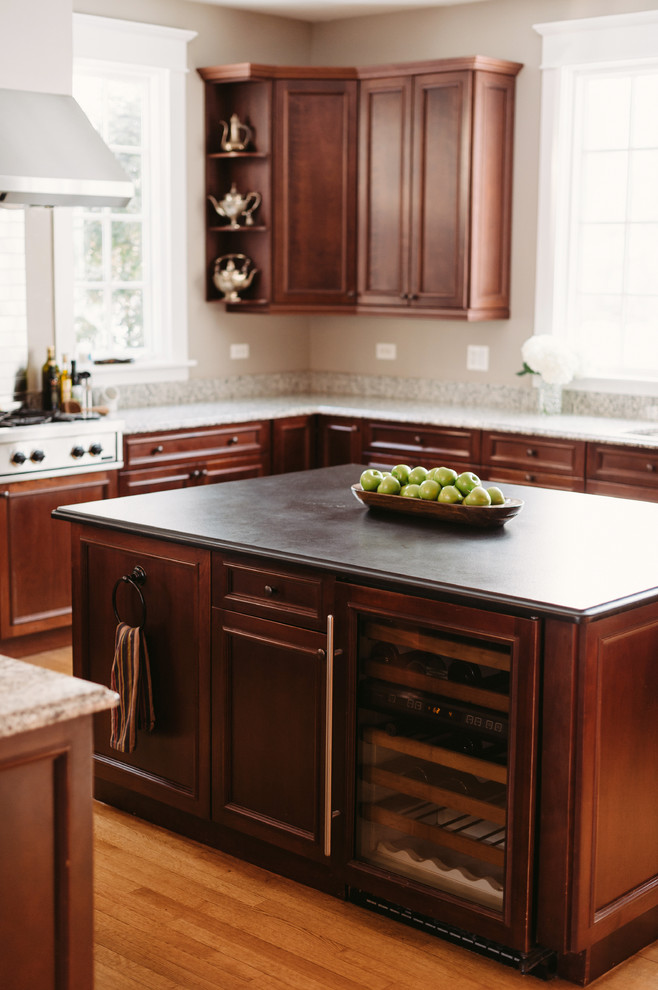 Inspiration for a large transitional u-shaped medium tone wood floor eat-in kitchen remodel with recessed-panel cabinets, brown cabinets, granite countertops, metallic backsplash, subway tile backsplash, stainless steel appliances and gray walls