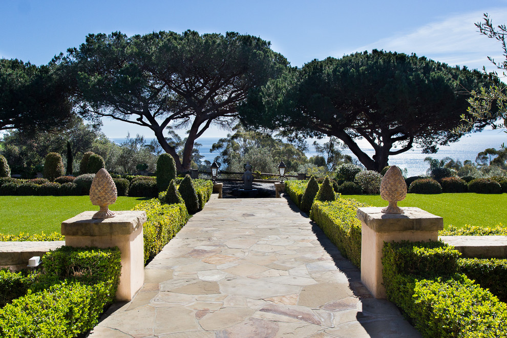 Photo of a large mediterranean front yard partial sun garden for summer in Los Angeles with a garden path and natural stone pavers.