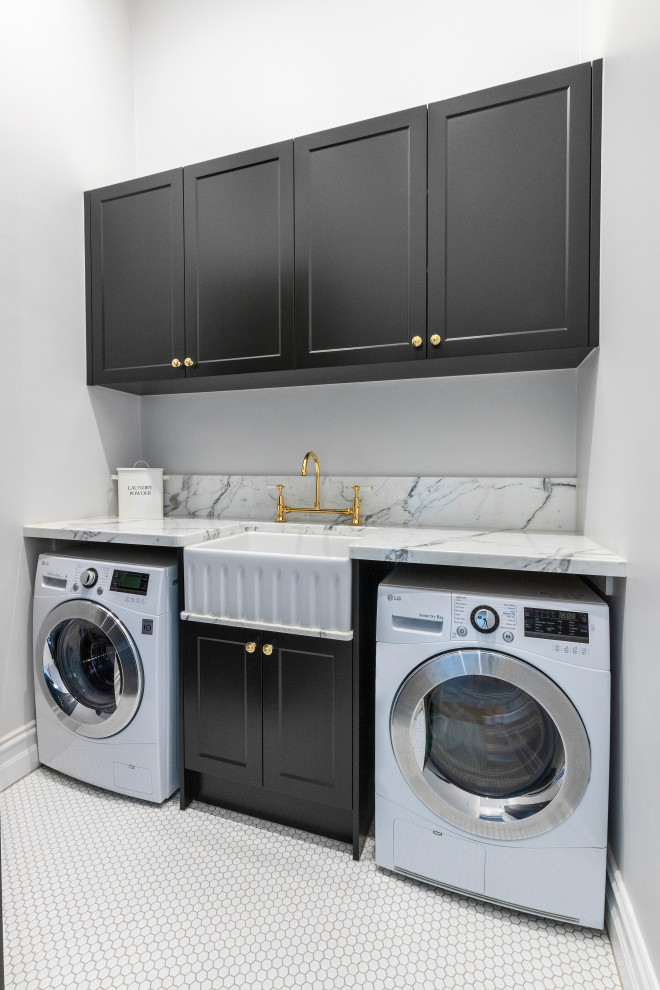 Photo of a mid-sized traditional galley dedicated laundry room in Melbourne with a farmhouse sink, recessed-panel cabinets, black cabinets, marble benchtops, white walls, porcelain floors, a side-by-side washer and dryer and white floor.