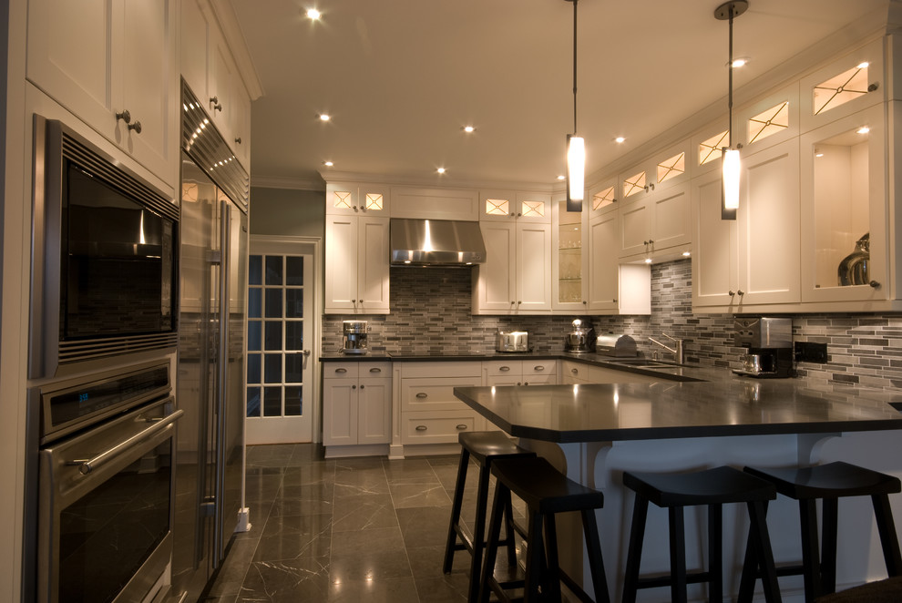 Inspiration for a transitional u-shaped marble floor eat-in kitchen remodel in Toronto with an undermount sink, recessed-panel cabinets, white cabinets, quartz countertops, multicolored backsplash, glass tile backsplash, stainless steel appliances and a peninsula