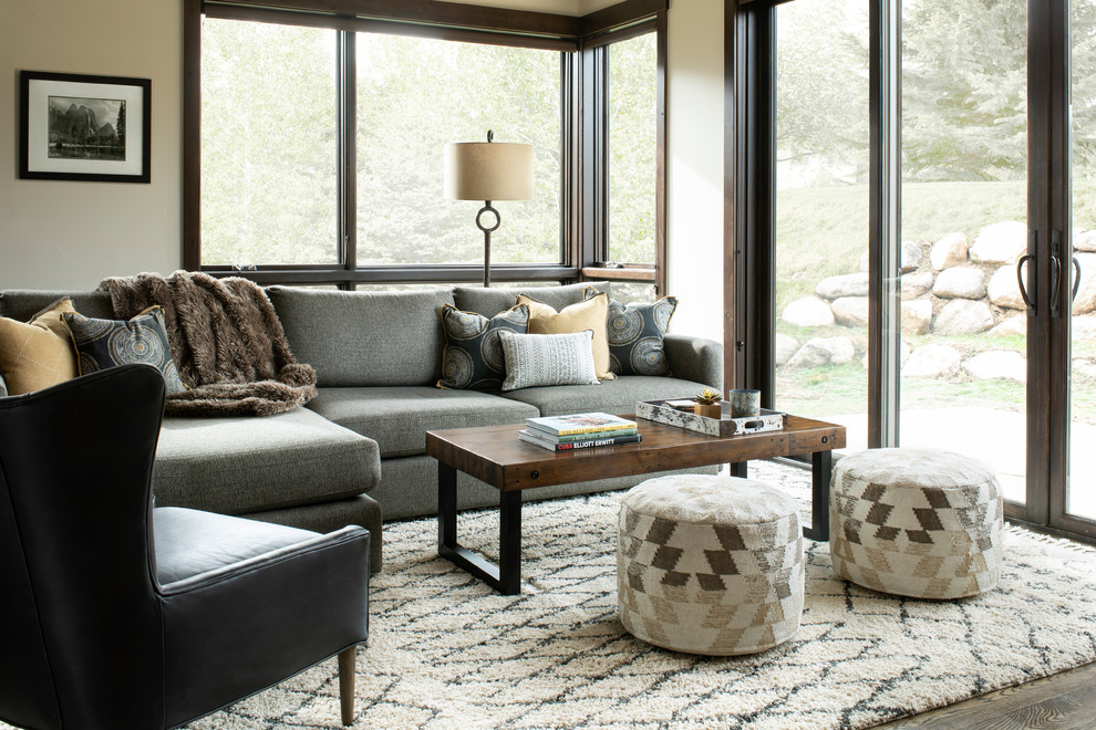 This is an example of a country living room in Denver with beige walls, dark hardwood floors and brown floor.