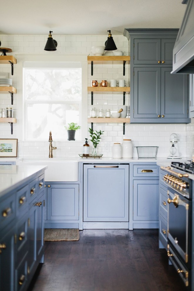 Example of a mid-sized classic dark wood floor and brown floor kitchen design in Dallas with a farmhouse sink, recessed-panel cabinets, blue cabinets, quartz countertops, white backsplash, subway tile backsplash, paneled appliances and an island