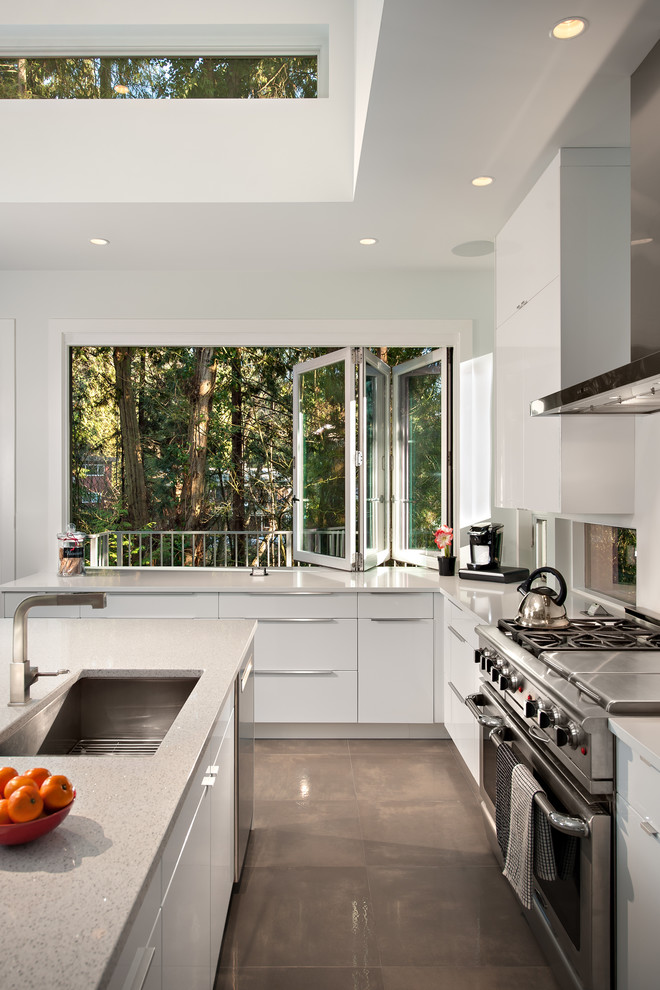Design ideas for a large contemporary u-shaped open plan kitchen in Vancouver with an undermount sink, flat-panel cabinets, white cabinets, stainless steel appliances, with island, marble benchtops and concrete floors.