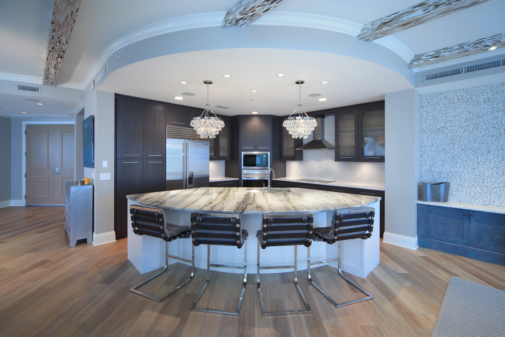 Inspiration for a contemporary l-shaped open plan kitchen in Tampa with flat-panel cabinets, dark wood cabinets, white splashback and stainless steel appliances.