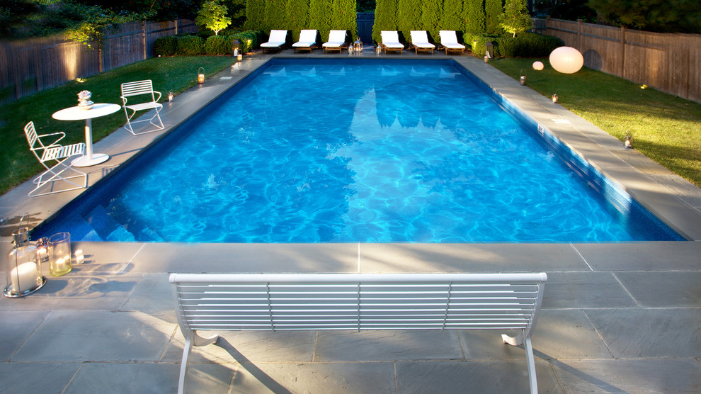 Example of a large tuscan backyard stone and rectangular pool design in New York