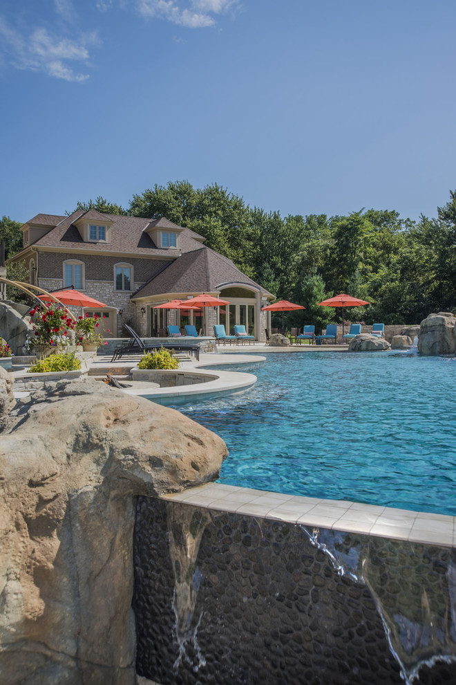 Inspiration for a large backyard stone and custom-shaped infinity pool fountain remodel in Chicago