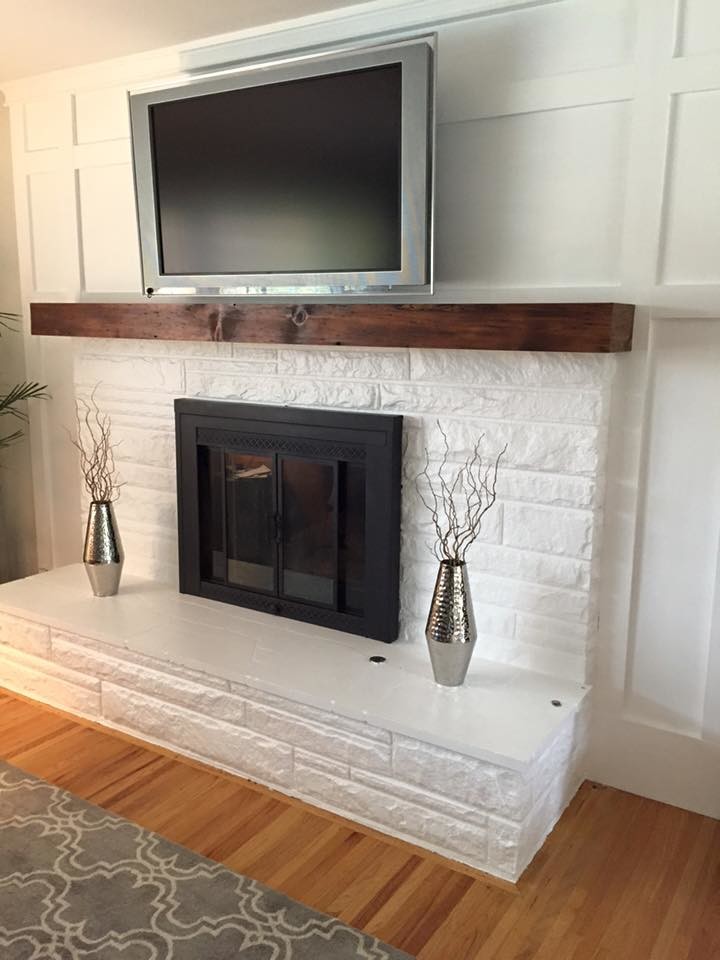 Photo of a mid-sized contemporary enclosed living room in Omaha with white walls, light hardwood floors, a standard fireplace, a brick fireplace surround and a wall-mounted tv.