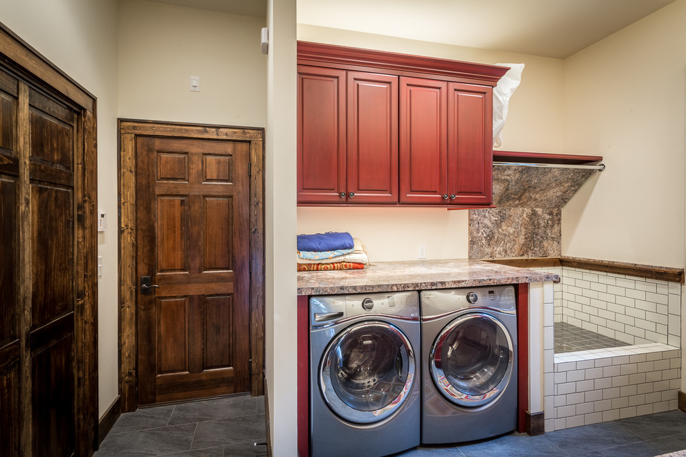 Expansive country galley utility room in Charlotte with a drop-in sink, raised-panel cabinets, red cabinets, laminate benchtops, beige walls, ceramic floors and a side-by-side washer and dryer.