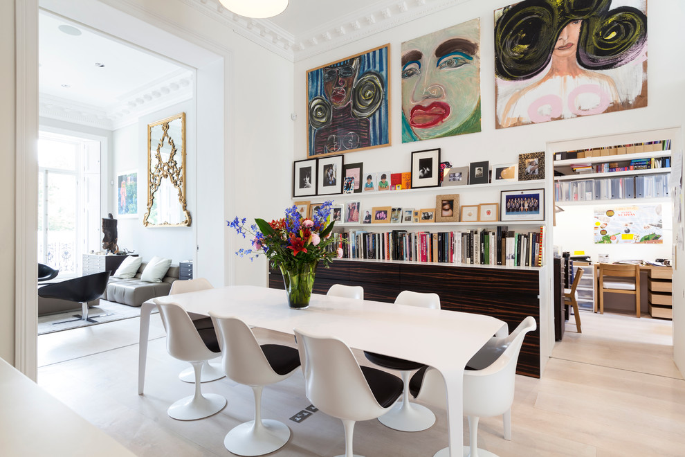 This is an example of a contemporary dining room in London with white walls and light hardwood floors.