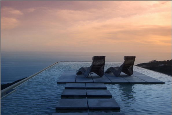 Photo of an expansive contemporary rooftop custom-shaped infinity pool in Los Angeles with a water feature.