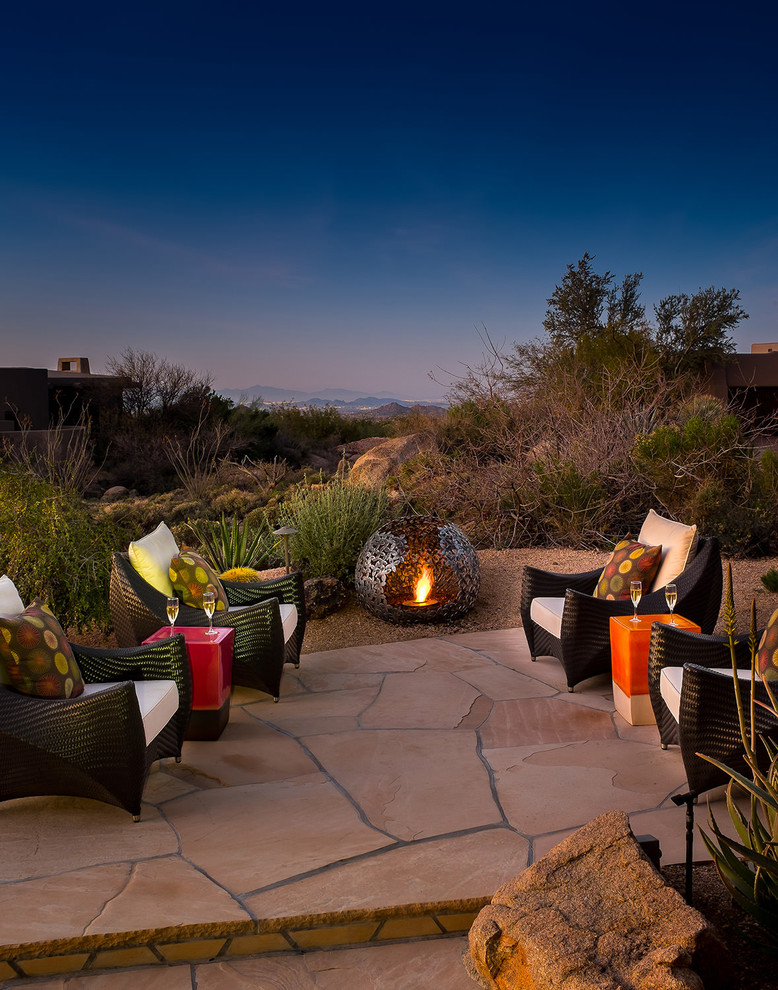 Photo of a backyard patio in Phoenix with a fire feature, natural stone pavers and no cover.