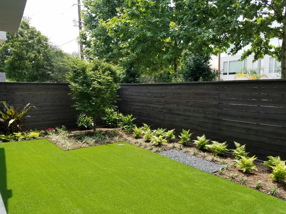 Inspiration for a mid-sized modern backyard partial sun garden in Houston.