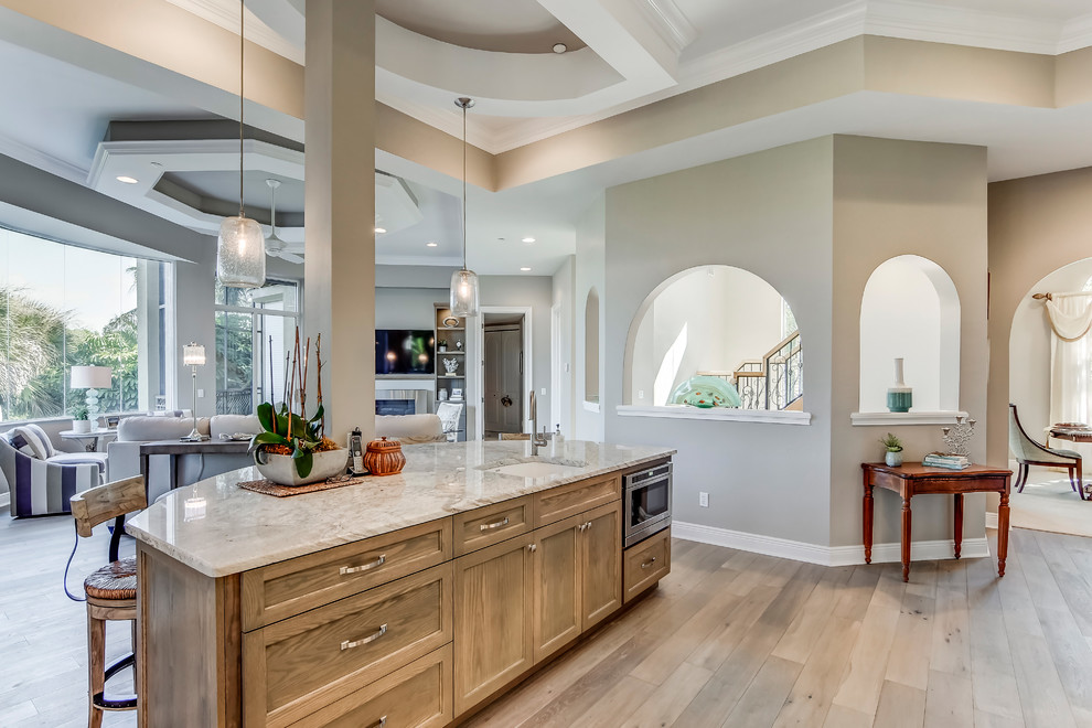 Mid-sized transitional l-shaped porcelain tile open concept kitchen photo in Miami with a drop-in sink, recessed-panel cabinets, medium tone wood cabinets, granite countertops, multicolored backsplash, glass sheet backsplash, stainless steel appliances and an island