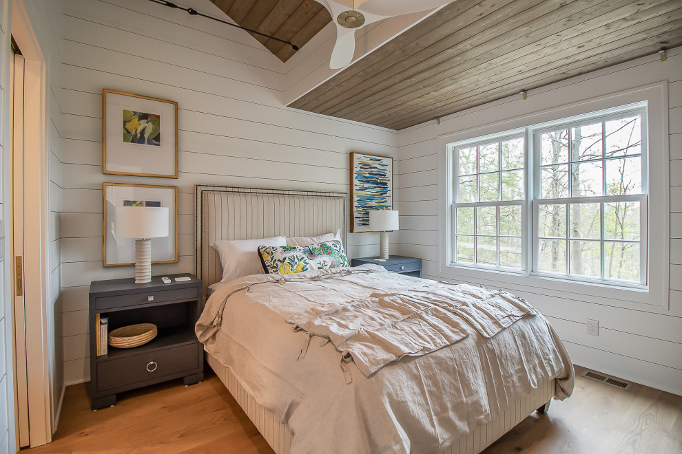 Пример оригинального дизайна: гостевая спальня среднего размера, (комната для гостей) в классическом стиле с белыми стенами, паркетным полом среднего тона, коричневым полом, деревянным потолком и стенами из вагонки