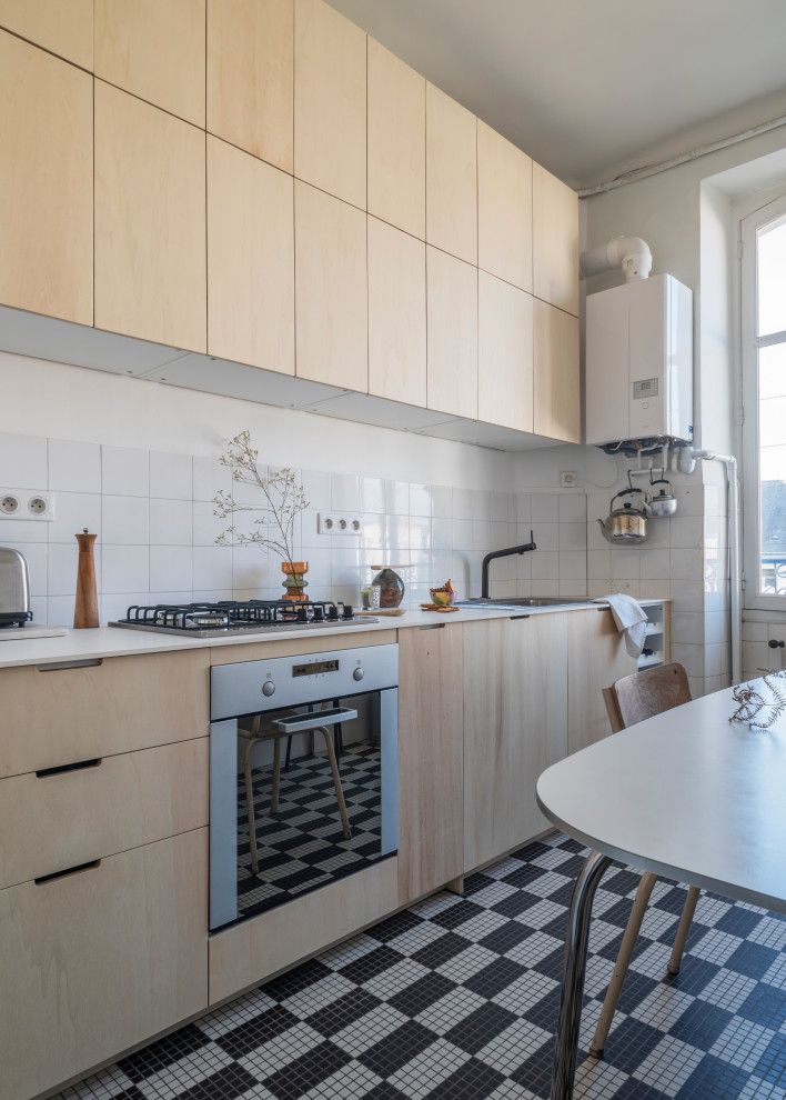 Design ideas for a small scandinavian single-wall separate kitchen in Nantes with a single-bowl sink, flat-panel cabinets, light wood cabinets, laminate benchtops, white splashback, ceramic splashback, stainless steel appliances, ceramic floors, no island and white benchtop.