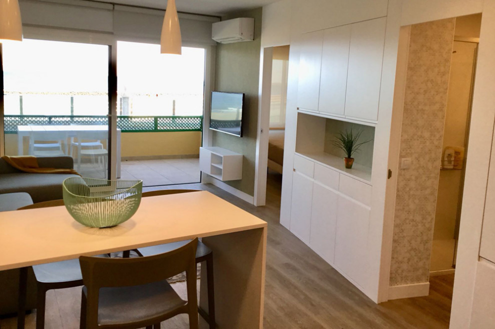 Ejemplo de comedor contemporáneo de tamaño medio con suelo vinílico, suelo marrón y paredes blancas