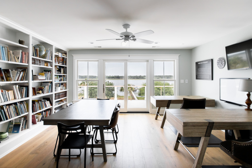 Klassisches Lesezimmer mit blauer Wandfarbe, braunem Holzboden und freistehendem Schreibtisch in Charleston