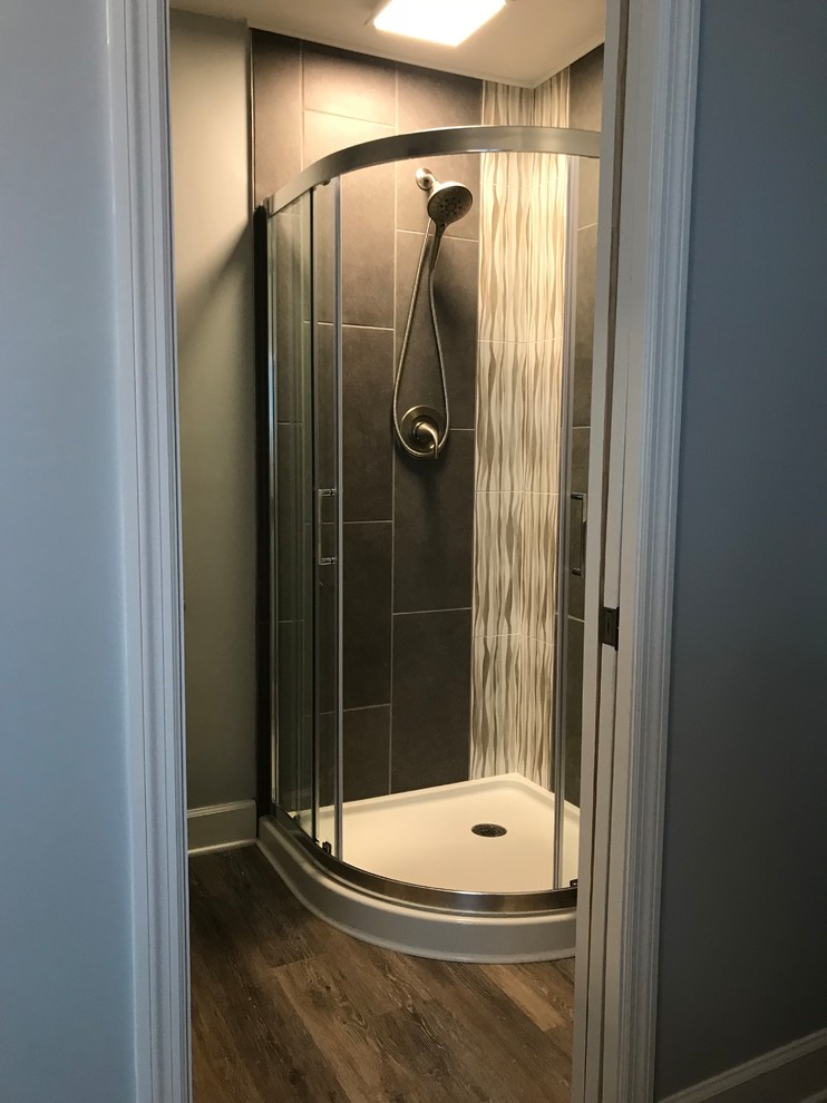 Small beach style master bathroom in Other with furniture-like cabinets, white cabinets, a corner shower, a two-piece toilet, gray tile, ceramic tile, grey walls, vinyl floors, an undermount sink, engineered quartz benchtops, grey floor, a sliding shower screen and grey benchtops.