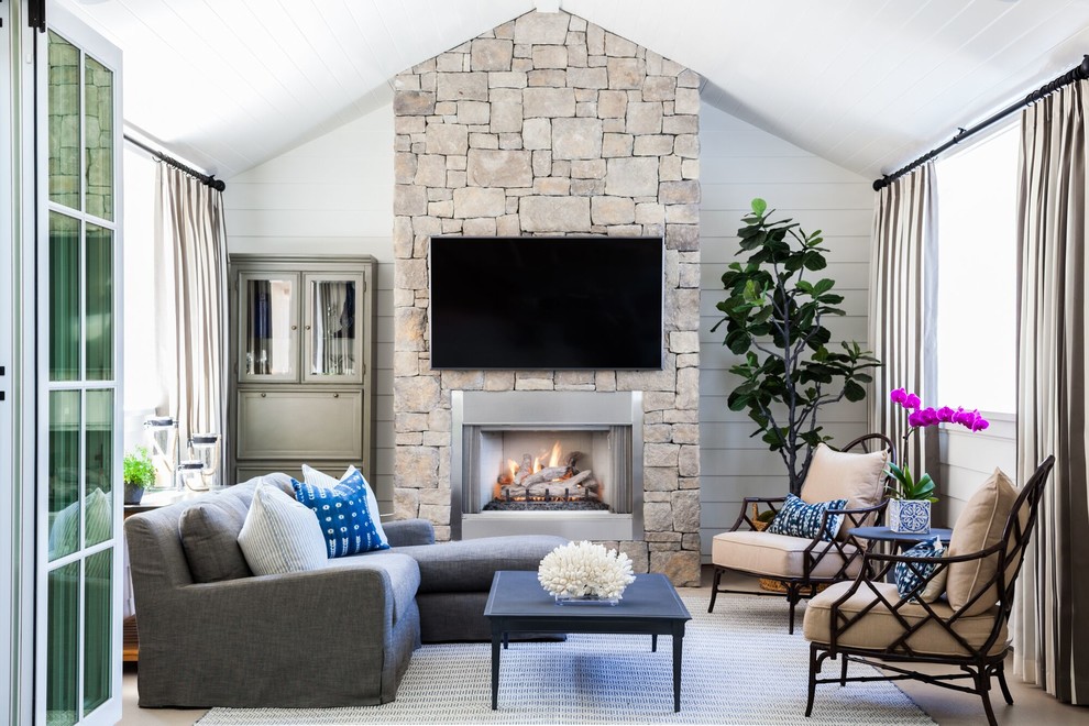 Photo of a mid-sized country sunroom in Orange County with concrete floors, a standard fireplace, a stone fireplace surround, a standard ceiling and beige floor.