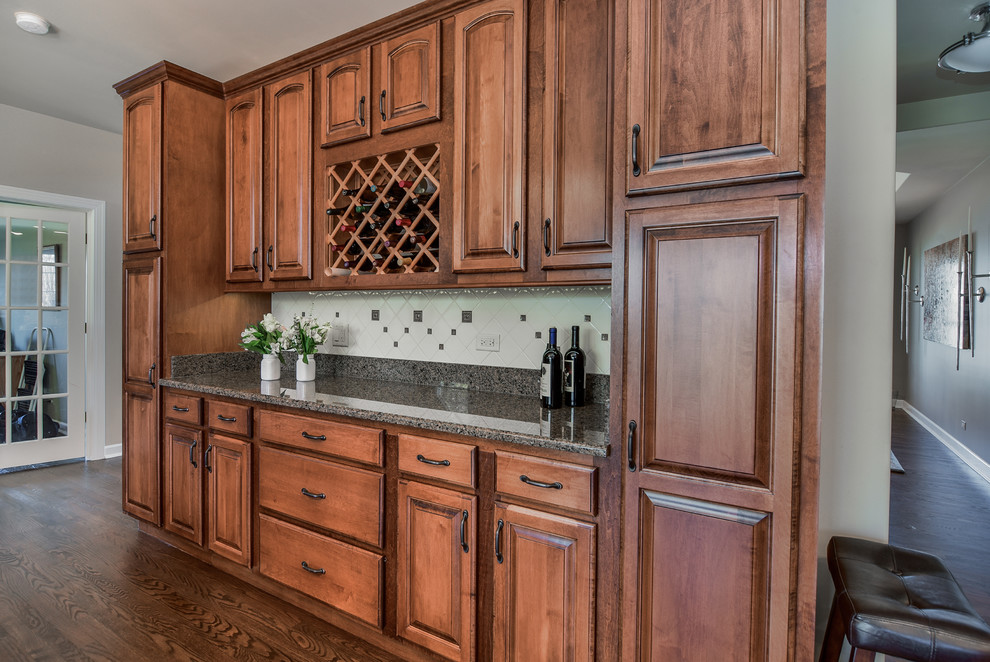 Eat-in kitchen - large transitional u-shaped medium tone wood floor eat-in kitchen idea in Chicago with a double-bowl sink, raised-panel cabinets, distressed cabinets, granite countertops, white backsplash, ceramic backsplash, stainless steel appliances and an island