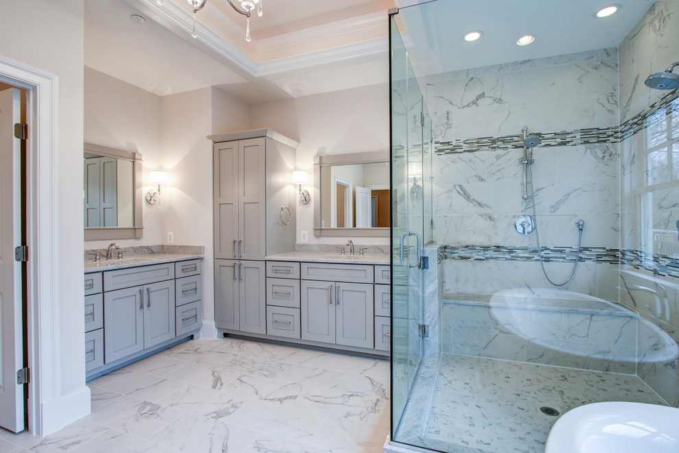 Example of a large transitional master multicolored tile and marble tile freestanding bathtub design in DC Metro with recessed-panel cabinets, gray cabinets, an integrated sink and marble countertops