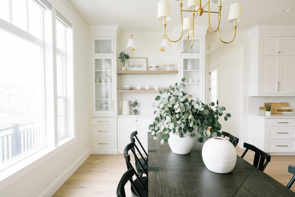 Inspiration for a transitional eat-in kitchen in Salt Lake City with a farmhouse sink, shaker cabinets, yellow cabinets, quartzite benchtops, white splashback, panelled appliances, light hardwood floors, multiple islands, beige floor and white benchtop.