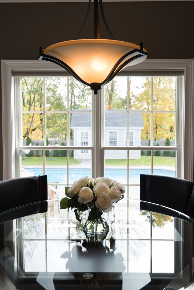 Mid-sized transitional u-shaped vinyl floor and brown floor kitchen photo with an undermount sink, recessed-panel cabinets, brown cabinets, quartz countertops, multicolored backsplash, porcelain backsplash, stainless steel appliances, a peninsula and multicolored countertops