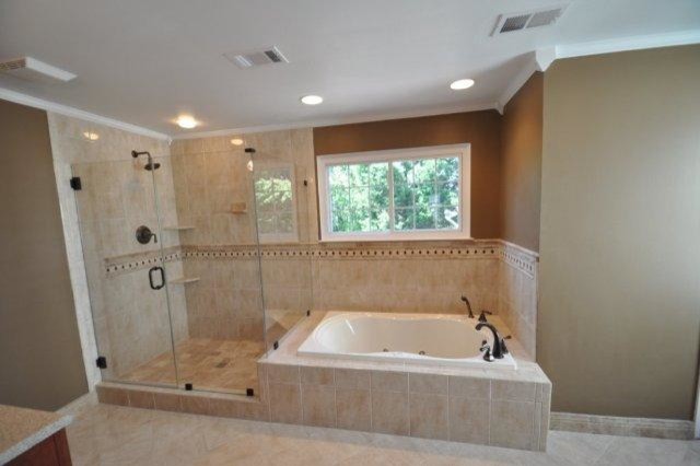 Photo of a large contemporary master bathroom in DC Metro with dark wood cabinets, a drop-in tub, an alcove shower, beige tile and brown walls.