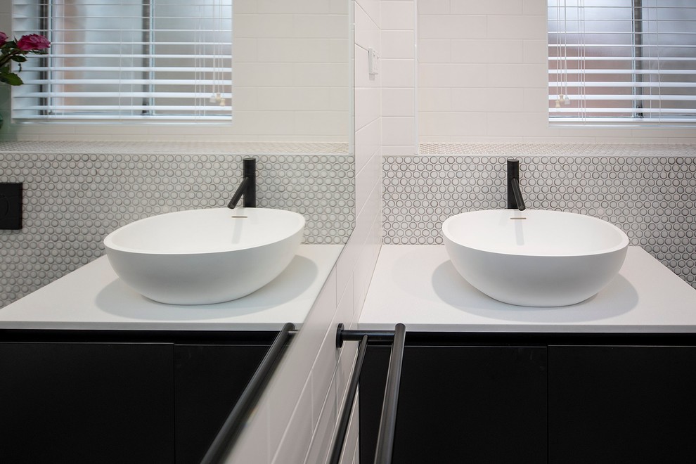 Photo of a small transitional bathroom in Sydney with flat-panel cabinets, a wall-mount toilet, black and white tile, porcelain tile, white walls, terra-cotta floors, a vessel sink, engineered quartz benchtops, black floor, an open shower, white benchtops and a single vanity.