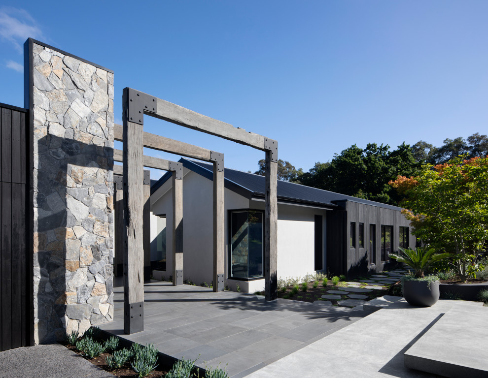 Großes, Zweistöckiges Modernes Einfamilienhaus mit Mix-Fassade, beiger Fassadenfarbe, Satteldach, Blechdach und schwarzem Dach in Melbourne